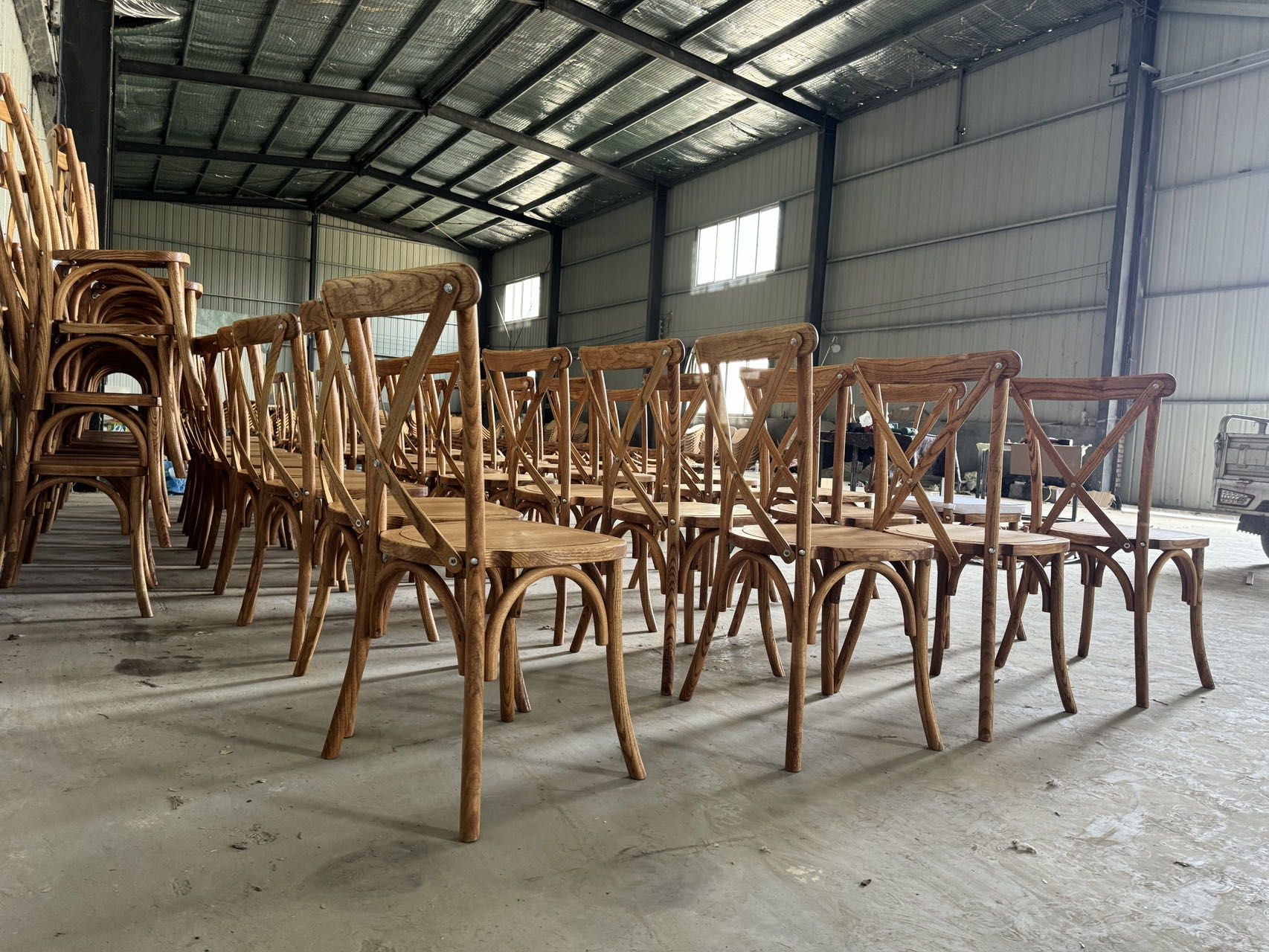 Factory storage of stacked cross back chairs ready for shipment